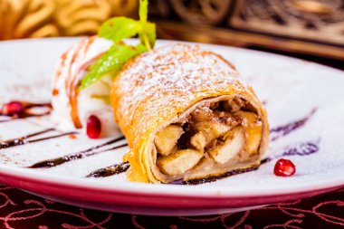 Strudel apple ve beyaz plaka üzerinde dondurma ile