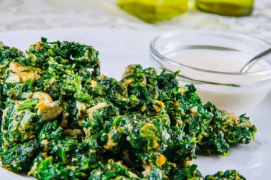 Beyaz tabakta Yumurta ile kızarmış ıspanak