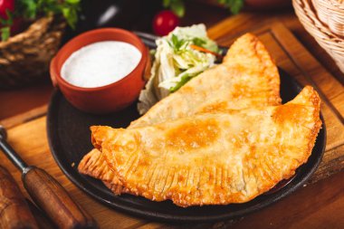 Geleneksel Kırım Tatar yemek çizelgeleri, kıyma ve siyah tabakta ekşi krema ile servis ediliyor..