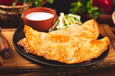 Geleneksel Kırım Tatar yemek çizelgeleri, kıyma ve siyah tabakta ekşi krema ile servis ediliyor..