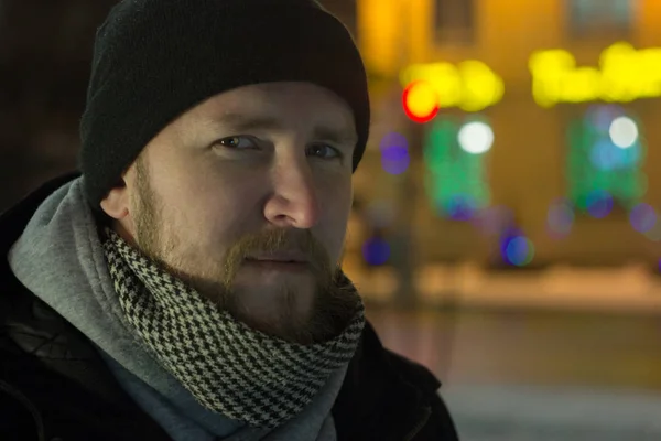 Un hombre con barba en el fondo de la señalización urbana y las luces — Foto de Stock