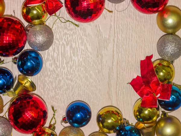 Frame of Christmas balls on a wooden table with copyspace.