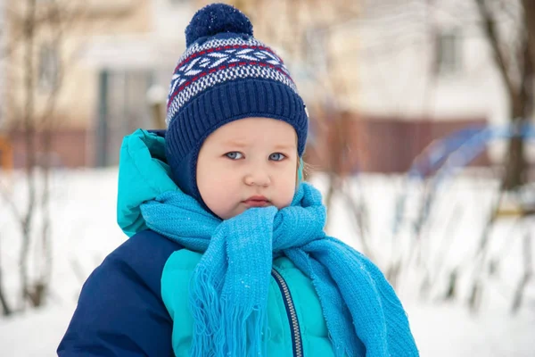 A tired boy on a walk looks straight. 