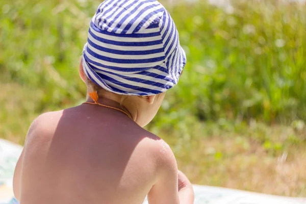 Een Jongen Met Een Gestreepte Hoed Zit Met Zijn Rug — Stockfoto