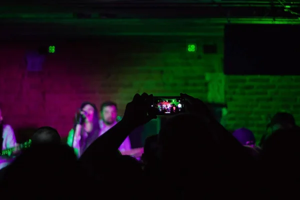 キャップの若い可愛い女の子がロッククラブで歌ってる ナイトクラブの若い音楽バンド 魂のための音楽 — ストック写真