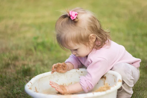 Een Klein Meisje Speelt Enthousiast Met Modder Een Bassin Binnenplaats — Stockfoto