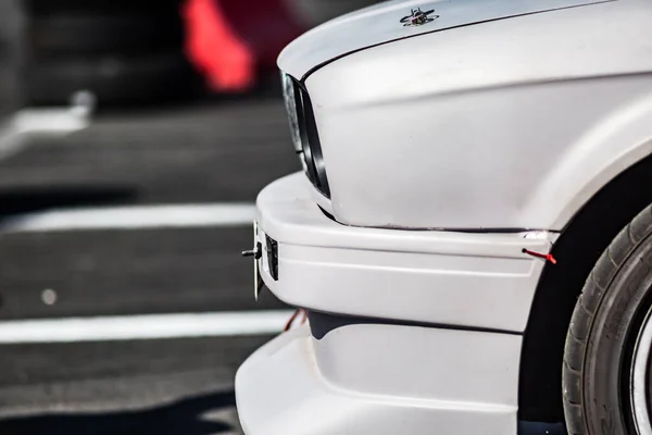 Pare-chocs blanc d'une voiture de sport blanche sur fond d'asphalte au soleil — Photo