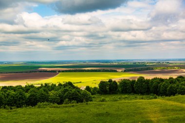 Yazın mavi gökyüzü ve bulutlarla ufukta görünen manzara.