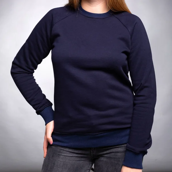 stock image dark blue plain sweatshirt dressed on a girl on a light background. Vertical orientation. High quality photo