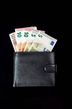 Siyah arka plandaki siyah bir cüzdandan çıkan para euro banknotları. 5, 10, 50 avro. Dikey yönelim. 