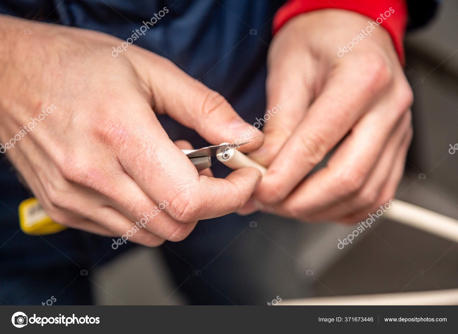 Cutting cable insulation with a segmented knife. White cable, yellow