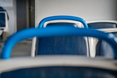 Boş bir trende mavi tırabzanları olan mavi ve beyaz koltuklar. Yakın plan. Yatay yönelim. 