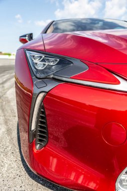 Tampondan kırmızı bir arabanın ön görüntüsü. Güneşli günü kapat. Dikey yönelim. 