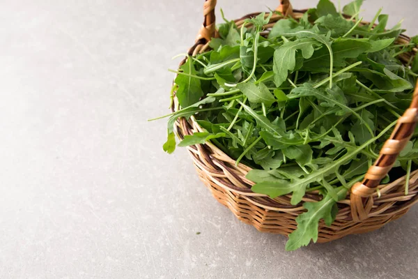 Insalata rucola fresca su fondo grigio pietra — Foto Stock