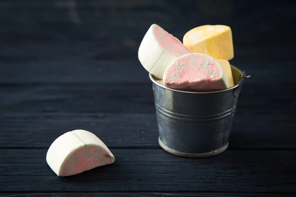 Los malvaviscos en forma de los trozos de frutas en el cubo pequeño sobre blu — Foto de Stock