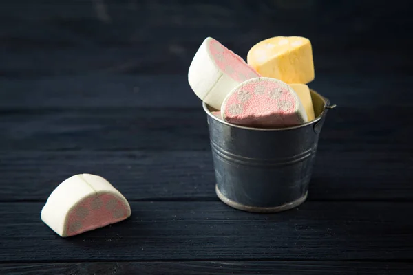 Los malvaviscos en forma de los trozos de frutas en el cubo pequeño sobre blu — Foto de Stock