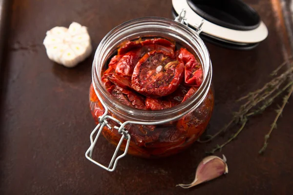 Zongedroogde tomaten met kruiden en zeezout in olijfolie in een gla — Stockfoto