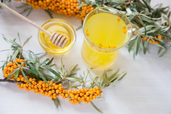 Tea with sea buckthorn and honey on a light background. — Stock Photo, Image