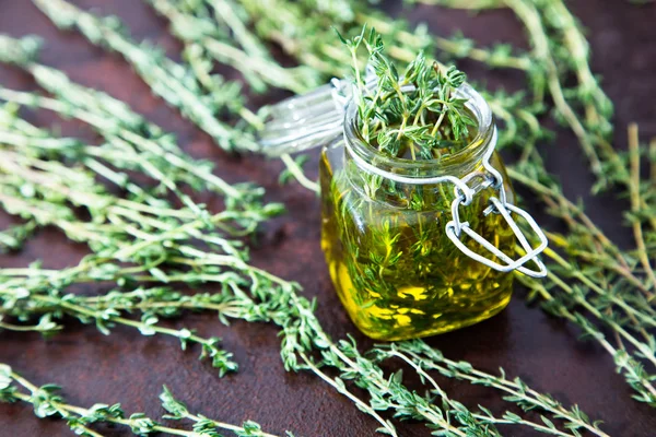 Thyme oil. Thyme essential oil jar glass bottle and branches of — Stock Photo, Image