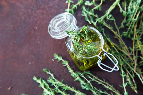 Thyme oil. Thyme essential oil jar glass bottle and branches of — Stock Photo, Image