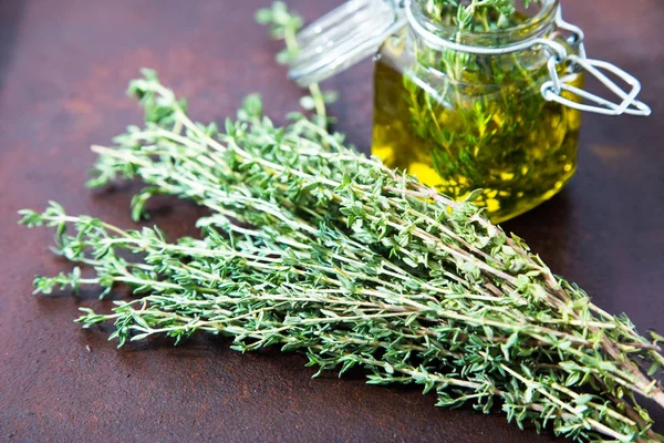Thyme oil. Thyme essential oil jar glass bottle and branches of — Stock Photo, Image
