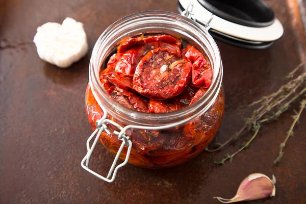 Zongedroogde tomaten met kruiden en zeezout in olijfolie in een gla — Stockfoto