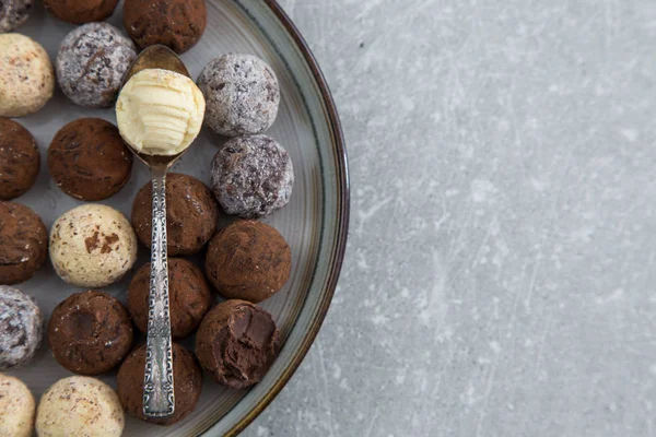 ทรัฟเฟิลช็อคโกแลตที่มีผงโกโก้ มะพร้าว และเฮเซลนัทสับบนจานของหวาน — ภาพถ่ายสต็อก