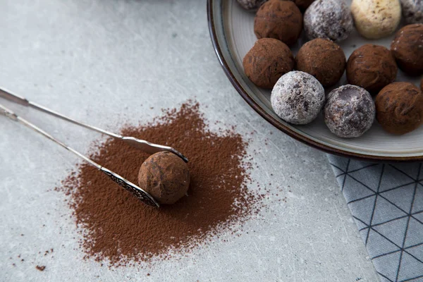 Blandade chokladtryfflar med kakaopulver, kokos och hackade hasselnötter på en desserttallrik — Stockfoto