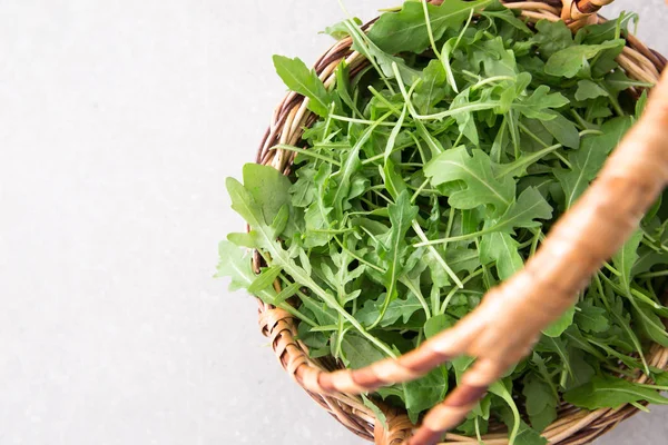 Färsk rucola sallad på en grå sten bakgrund — Stockfoto