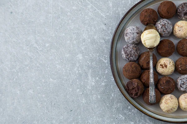 ทรัฟเฟิลช็อคโกแลตที่มีผงโกโก้ มะพร้าว และเฮเซลนัทสับบนจานของหวาน — ภาพถ่ายสต็อก