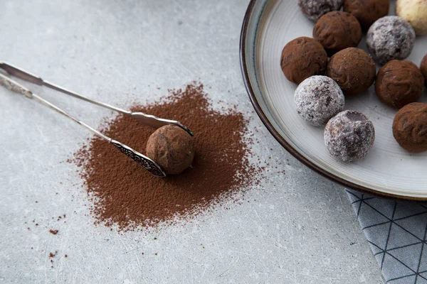 Blandade chokladtryfflar med kakaopulver, kokos och hackade hasselnötter på en desserttallrik — Stockfoto