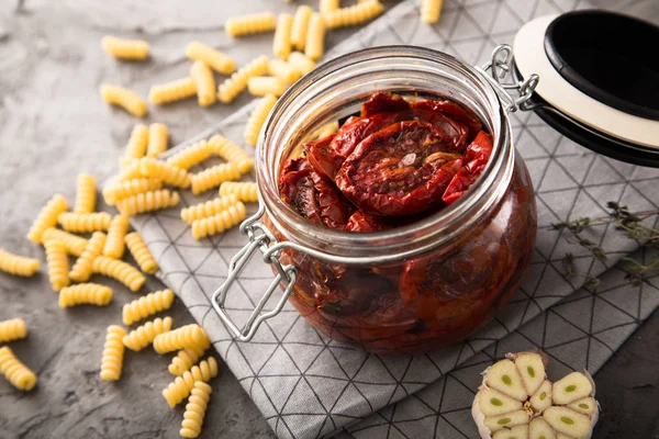 Zongedroogde tomaten met kruiden en zeezout in olijfolie in een glazen pot — Stockfoto