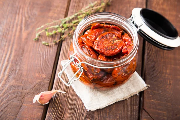 Zongedroogde tomaten met kruiden en zeezout in olijfolie in een gla — Stockfoto