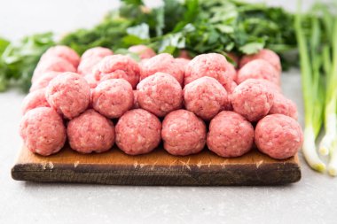 Bir taş rustik ahşap kesme tahtası üzerinde çiğ köfte 