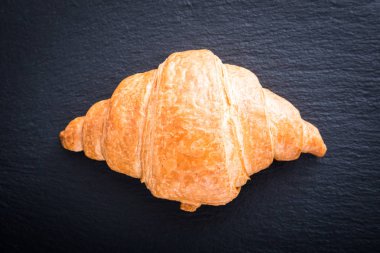 Siyah bir arkaplanda taze kruvasan. Üst görünüm