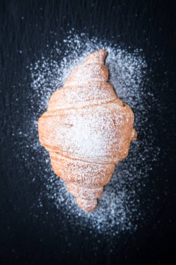 Siyah bir arkaplanda taze kruvasan. Üst görünüm