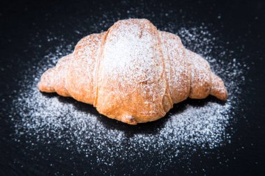 Siyah bir arkaplanda taze kruvasan. Üst görünüm