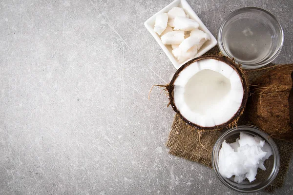 Coconut with coconut oil in jar on wooden background — Stock Photo, Image