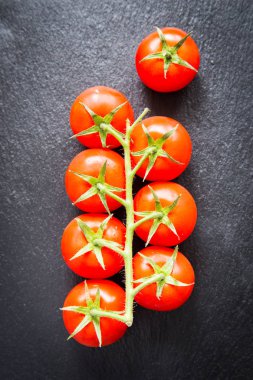 Baharat siyah bir zemin üzerine taze kiraz domates. 