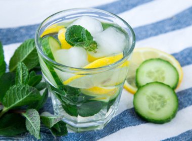 Limon ve salatalık su mavi renkli ahşap arka plan üzerinde Detoks