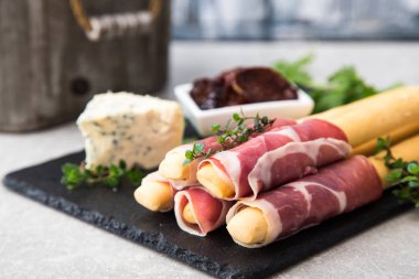 Appetizer with  prosciutto, ham, blue cheese and sun dried tomat clipart