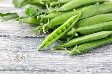 Ahşap zemin üzerine yeşil bezelye. hearthy taze ev yapımı bezelye.