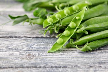 Ahşap zemin üzerine yeşil bezelye. hearthy taze ev yapımı bezelye.