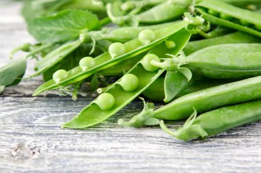 Ahşap zemin üzerine yeşil bezelye. hearthy taze ev yapımı bezelye.