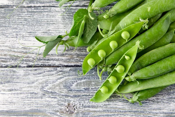 Ahşap zemin üzerine yeşil bezelye. hearthy taze ev yapımı bezelye.