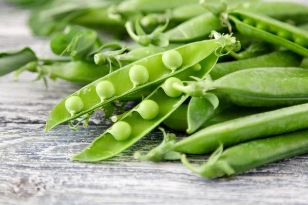 Ahşap zemin üzerine yeşil bezelye. hearthy taze ev yapımı bezelye.