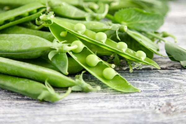 Ahşap zemin üzerine yeşil bezelye. hearthy taze ev yapımı bezelye.