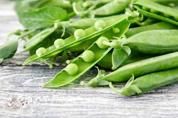 Ahşap zemin üzerine yeşil bezelye. hearthy taze ev yapımı bezelye.