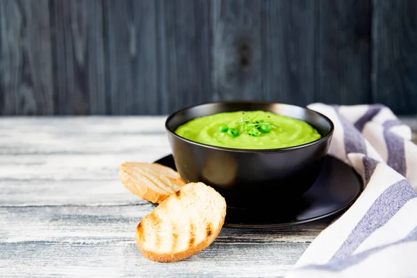 Домашний суп из пюре с зеленым горохом и микрозеленью . — стоковое фото