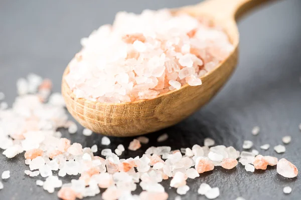 Himalayan pink crystal salt. spoon of pink himalayan salt on sla